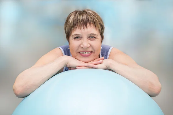 Portrait of senior woman looking at camera and smiling in sport gym