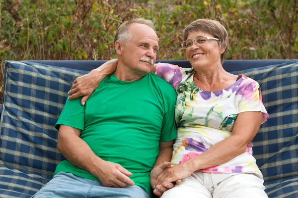 Happy senior couple in love sitting outside in a garden
