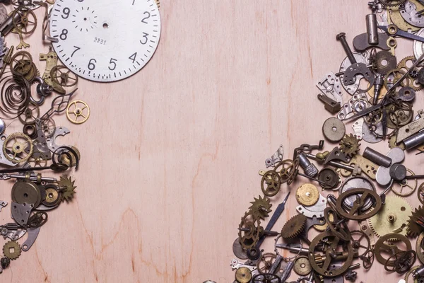 Mechanisms and cogwheels of old watch on wooden table