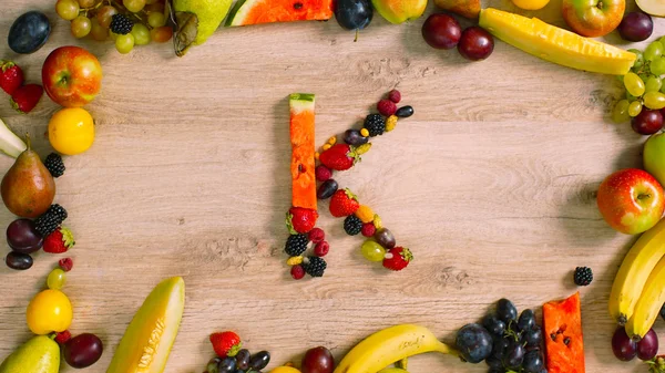 Fruits made letter K. The composition of bright ripe fruits. Alphabet made of fruits.