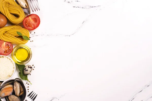 Pasta with ingredients over white marble table