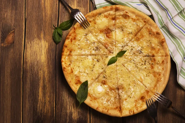 Four cheese pizza with basil and oregano