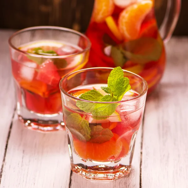 Sangria with fruits and mint leaves in glasses