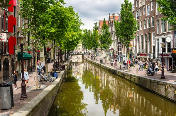 People Strolling along a Canal in Amsterdam City Centre