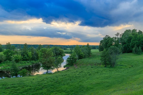 Summer landscape, river flows between green banks