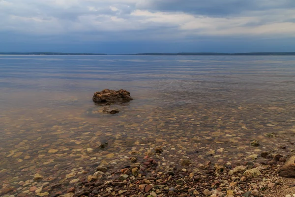 Great Russian River Volga, a cloudy summer day, the stones shine through the water