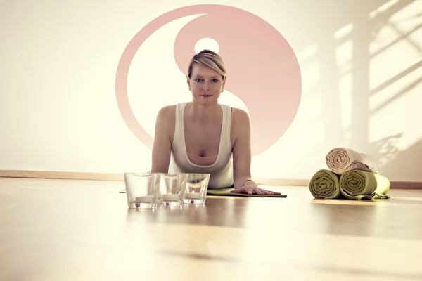 Woman on the floor on yoga mat in the background Yin and Yang