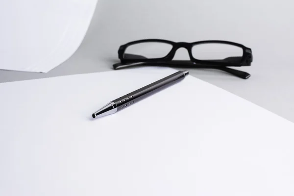 Blank white sheet of paper with pen and a glasses