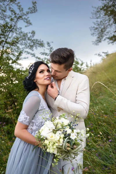 Young couple in love outdoor. Elegant bride and groom posing together outdoors on a wedding day. bride and groom in the Park. young couple in the woods. young couple in the grass. couple walking