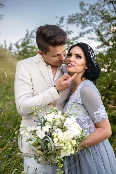 Young couple in love outdoor. Elegant bride and groom posing together outdoors on a wedding day. bride and groom in the Park. young couple in the woods. young couple in the grass. couple walking