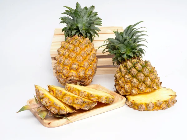 Pineapple and slice in wood box  white background