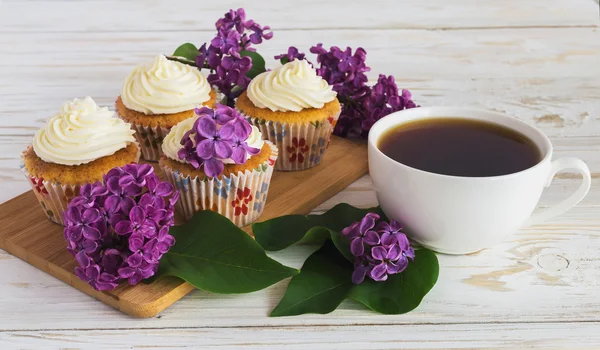 Cupcakes with cream, coffee and flowers