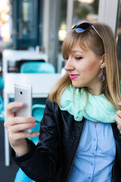 Young woman making self portrait using smartphone