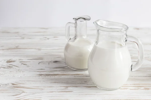 Milk jars on wooden background