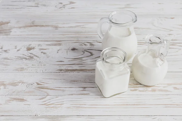 Milk jars on wooden background