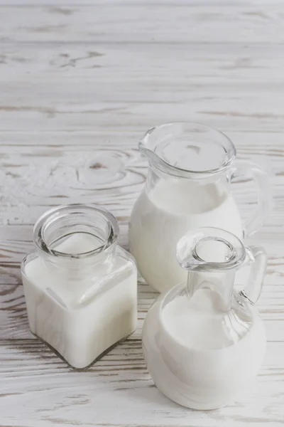 Milk jars on wooden background