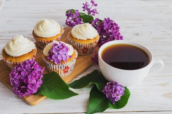 Cupcakes with cream, coffee and flowers