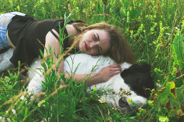 Young woman resting with Central Asian Shepherd dog