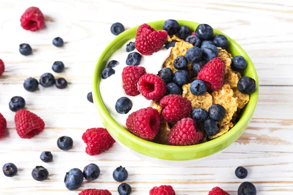 Healthy corn flakes breakfast on the white wooden table