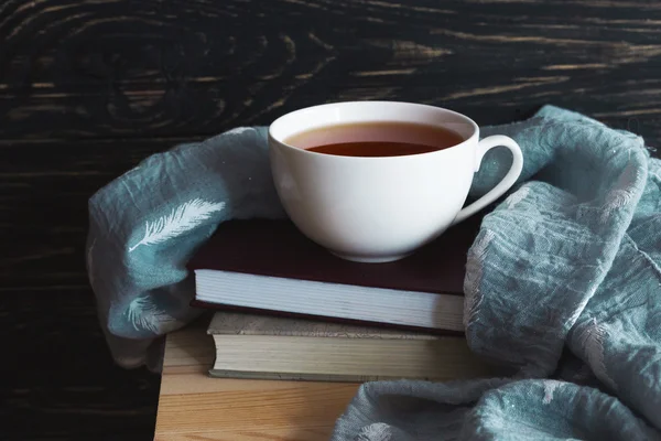 Warm knitted plaid, cup of tea and books