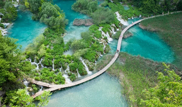 Top view of  Plitvice Lakes with waterfalls and wooden walkways with tourist