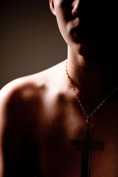 Teenage Boy Wearing Cross on Chain Around Neck