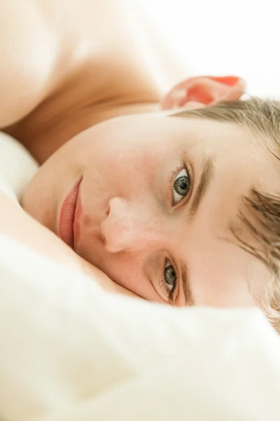 Teenage Boy Lying on Bed with Head on Hands