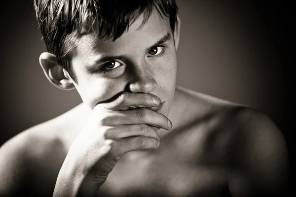 Serious Teenage Boy with Hand Covering Mouth