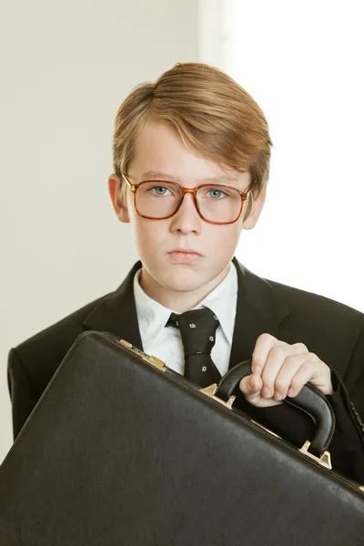 Serious boy in business suit and brief case