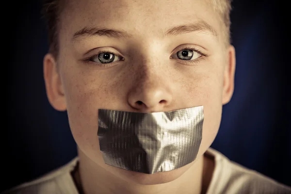 Young Teenage Boy with Duct Tape Covering Mouth