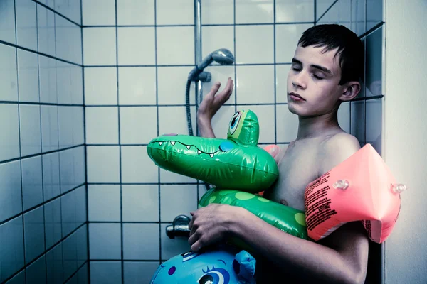 Teenage Boy Wearing Float Toys in Shower