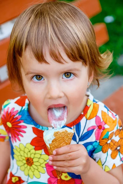 Happy little girl licking an ice cream