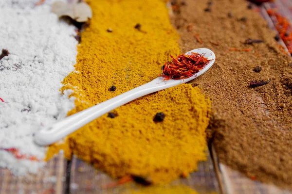 Various spices selection Saffron, turmeric, curry. different dry spices on a wooden background.