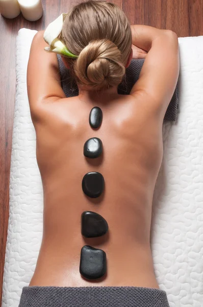 Stone massage. Beautiful woman getting spa hot stones massage in spa salon.