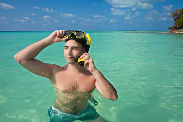 Men in blue ocean wearing yellow diving mask