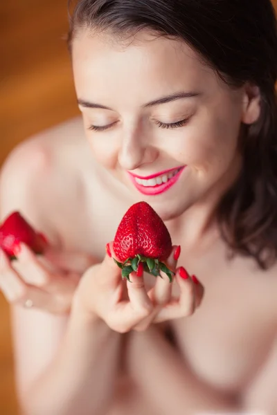 Photo of seductive female eating strawberry, closeup portrait redhead sensual woman biting berry