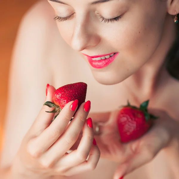 Photo of seductive female eating strawberry, closeup portrait redhead sensual woman biting berry