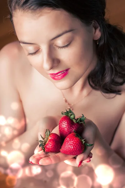 Photo of seductive female holding strawberry near face lips, closeup portrait redhead sensual woman biting berry