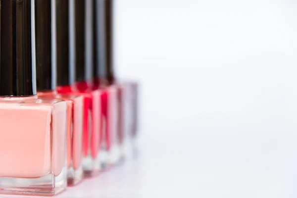 A palette of nail polish bottles on a white background