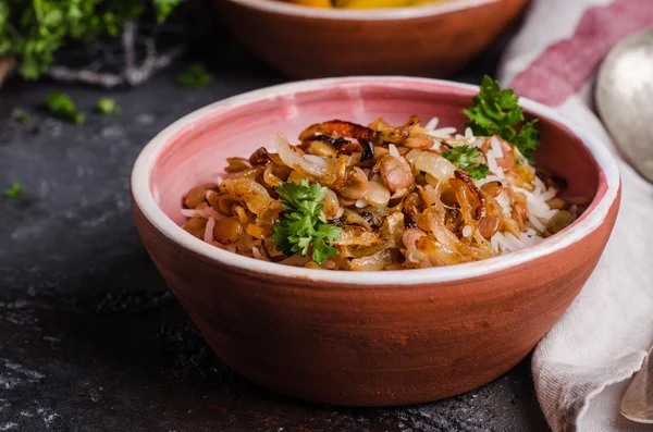 Mujadarra - arabian dish with rice, lentils and onion on dark  background. Ramadan food. Eastern cuisine. Selective focus