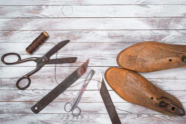 Set of tools for shoemaker on white wooden background. Copy space.