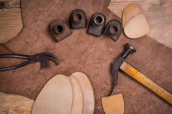 Set of leather craft tools on wooden background. Workplace for shoemaker.