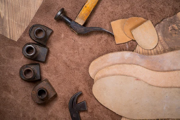 Set of leather craft tools on wooden background. Workplace for shoemaker.