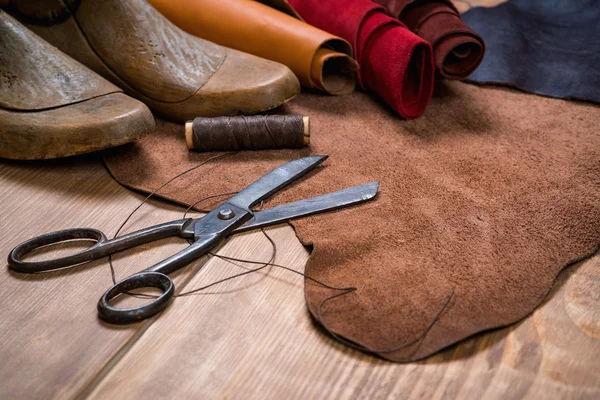 Set of leather craft tools on wooden background. Workplace for shoemaker.