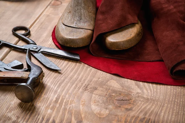 Set of leather craft tools on wooden background. Workplace for shoemaker.