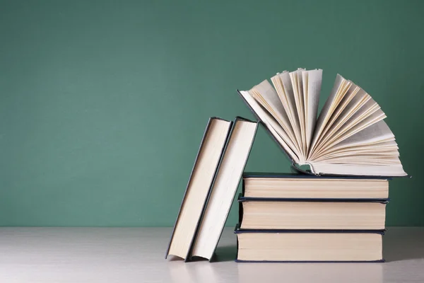 Open book, hardback books on wooden table. Education background. Back to school. Copy space for text.