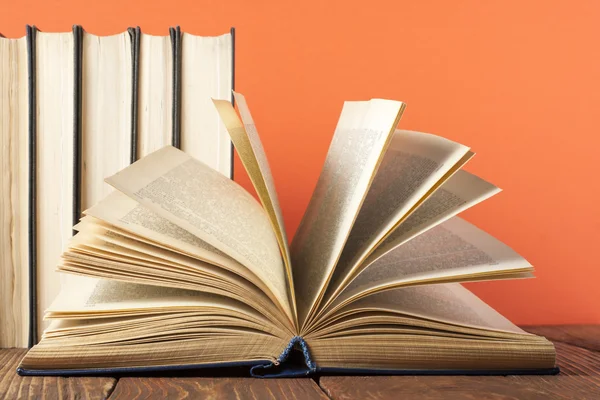 Open book, hardback books on wooden table. Education background. Back to school. Copy space for text.