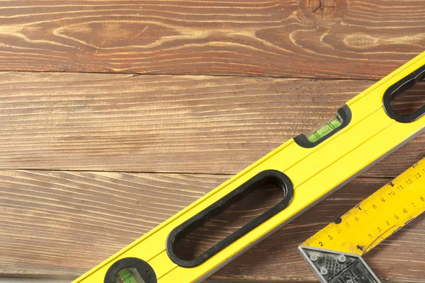 Set of tools at wooden table. meter measuring line construction level and square ruler maintenance concept