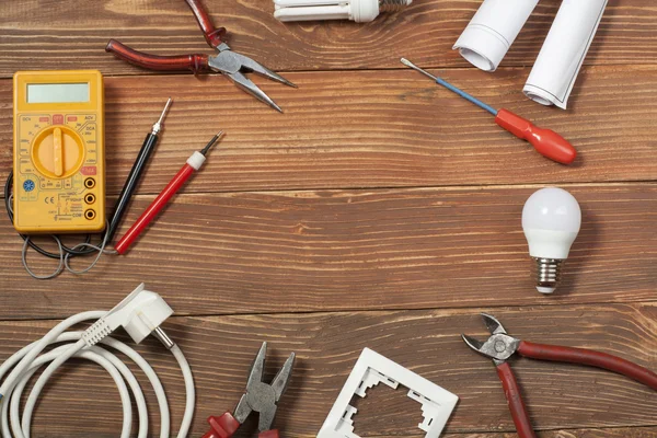 Set of electrical tool on wooden background. Accessories for engineering work, energy concept.