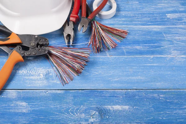 Set of electrical tool on wooden background. Accessories for engineering work, energy concept.